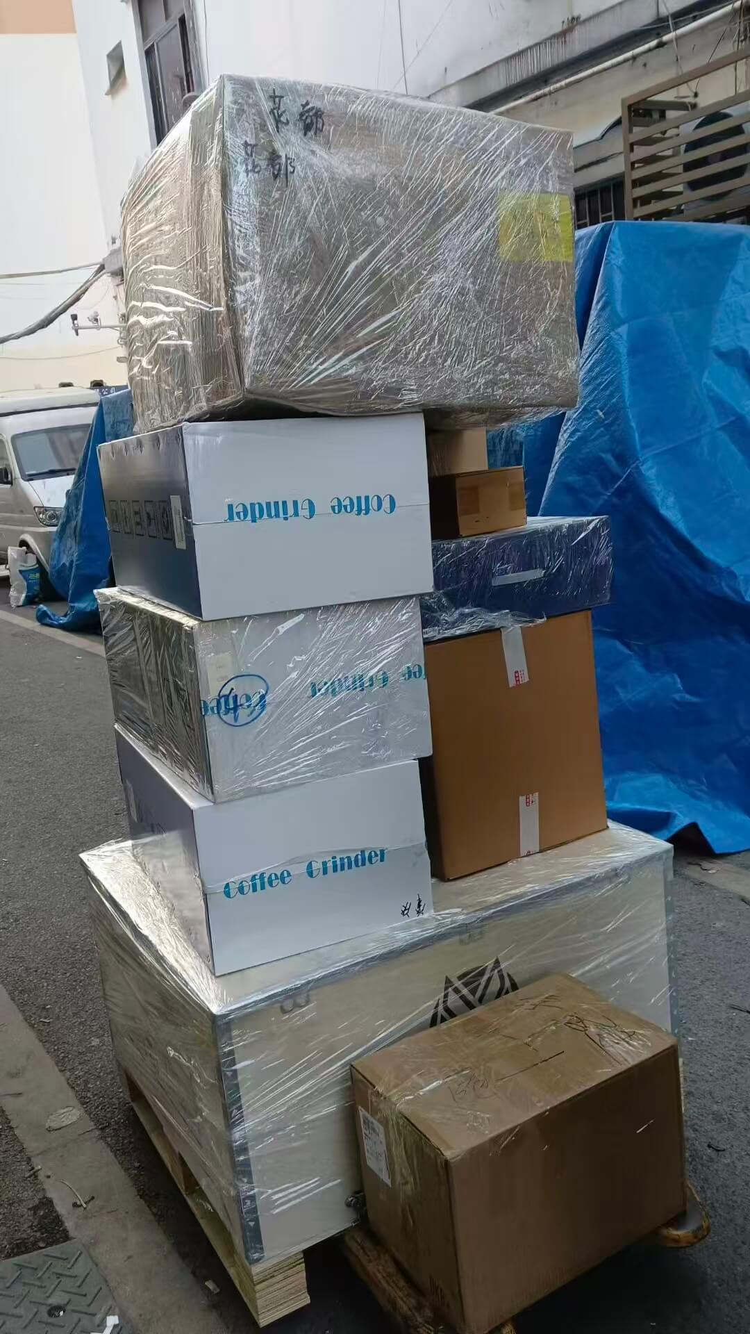 A coffee equipment distributor standing in front of stocked shelves with espresso machine parts including portafilters and group gaskets